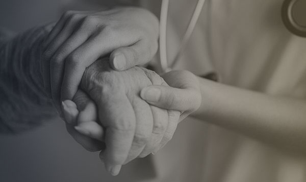 An allyon healthcare subcontractor holding a patient's hand