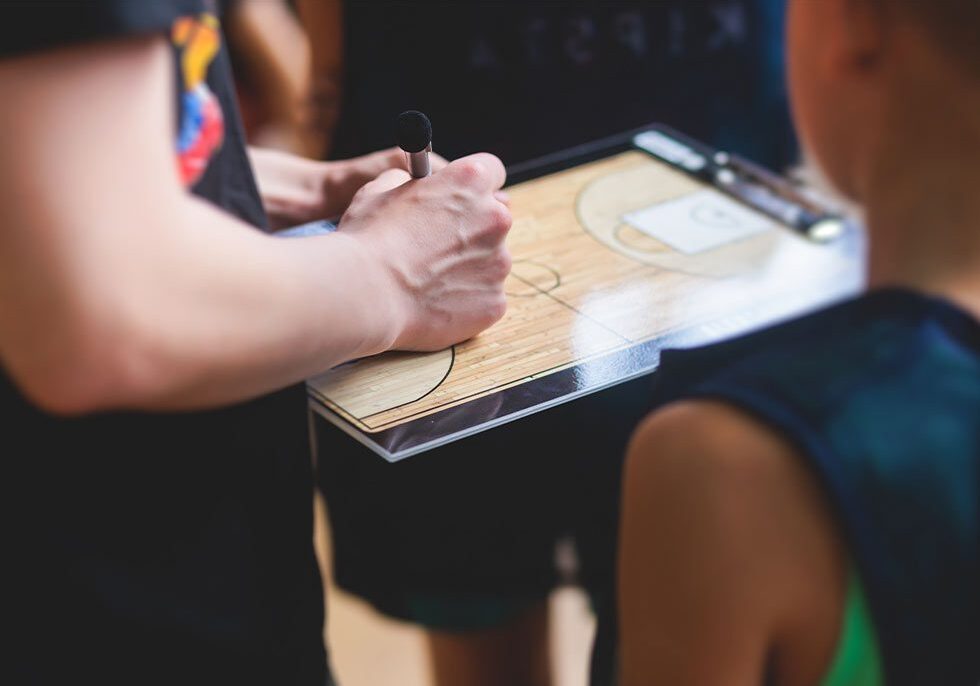close-up of youth basketball coach holding clipboard